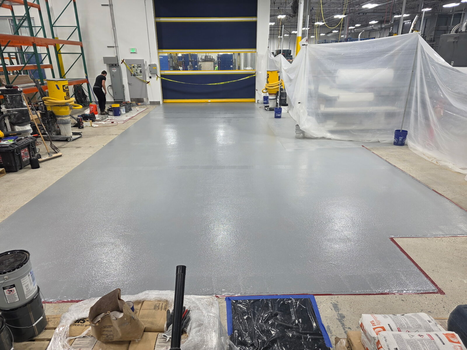 Gray epoxy floor coating installed in a large manufacturing bay