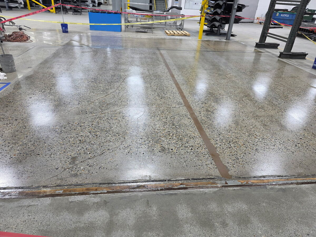Close-up of polished concrete floor with expansion joint in a manufacturing facility