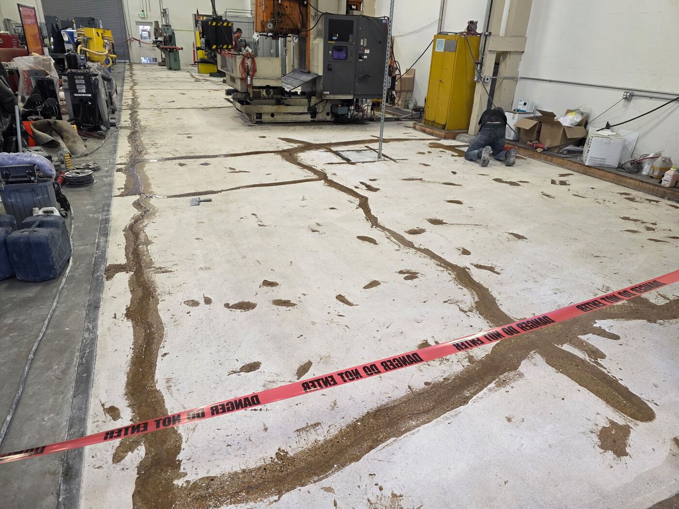 Crew member repairing an expansion joint mid-installation in a manufacturing facility