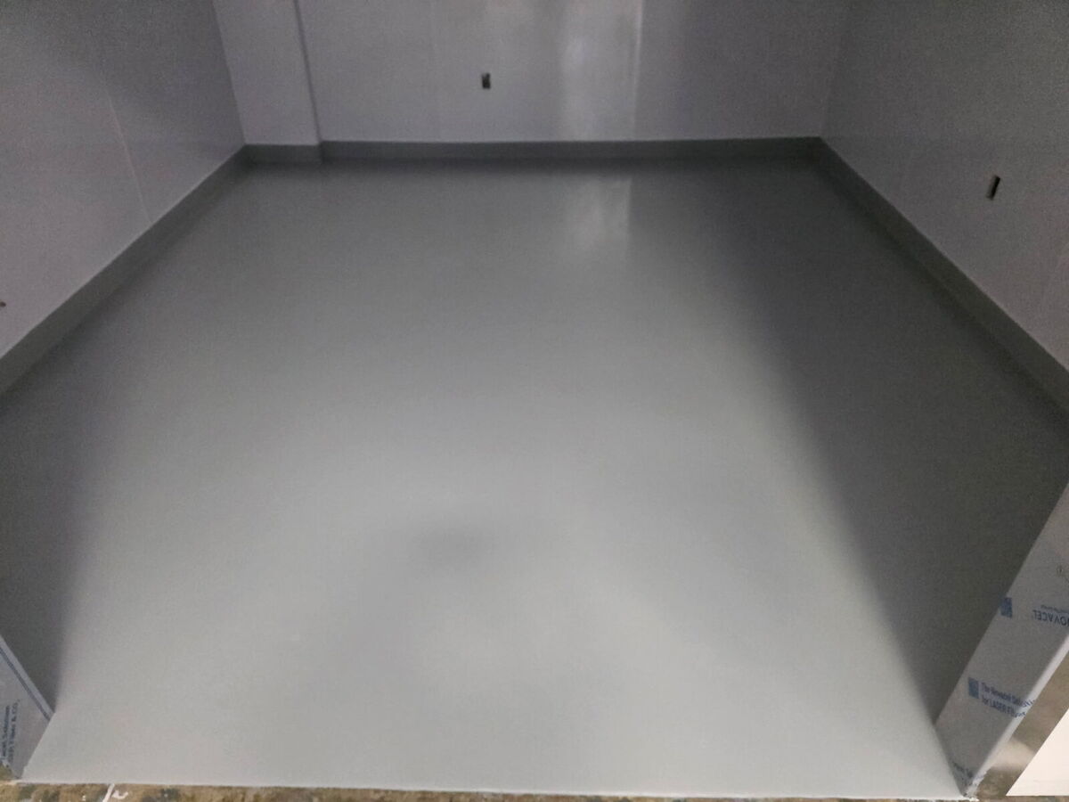 Small storage room floor coated in gray epoxy